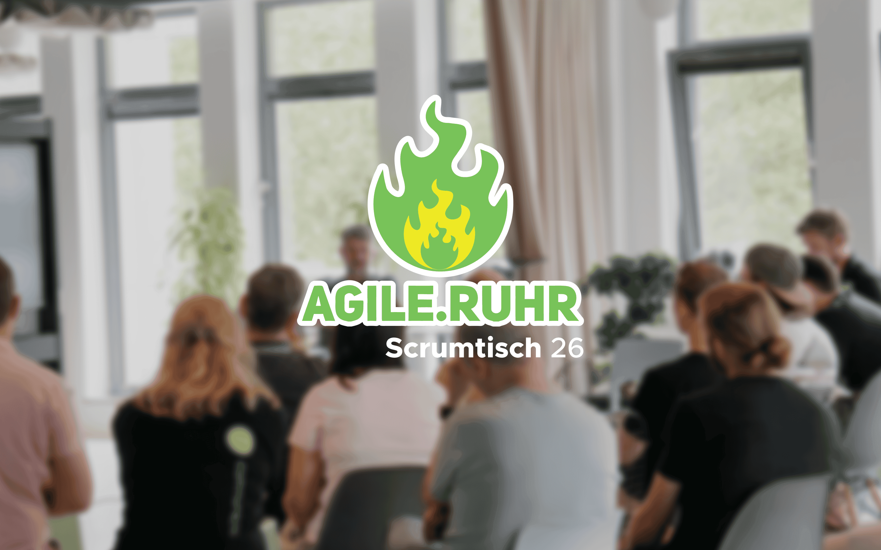 Verschwommenes Foto einer Veranstaltung mit sitzenden Teilnehmenden in einem hellen Raum. In der Mitte befindet sich das Logo „AGILE.RUHR“ mit einer grünen Flamme sowie der Schriftzug „Scrumtisch 26“.